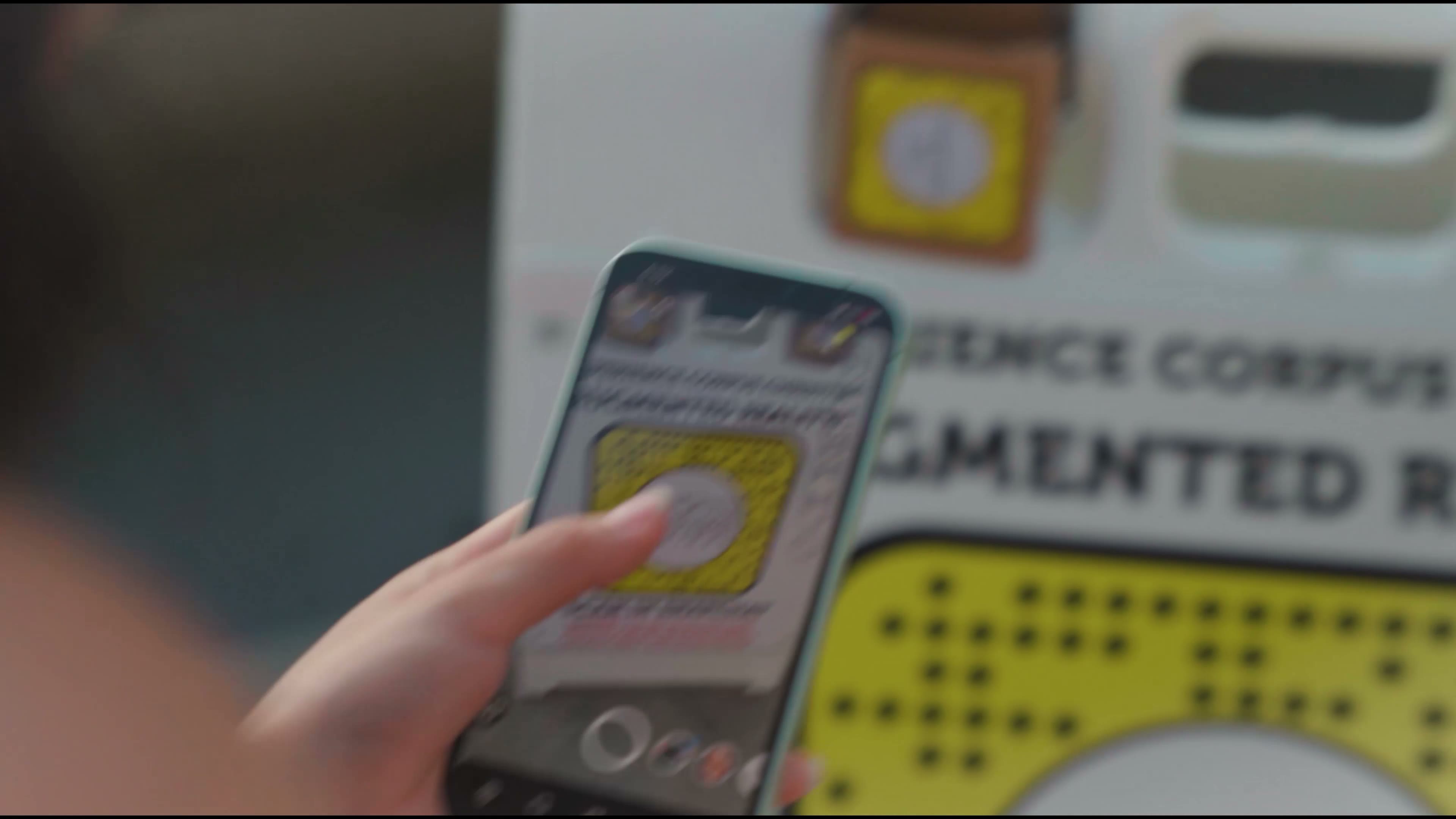 A person scanning an AR code on printed signage with a smartphone.